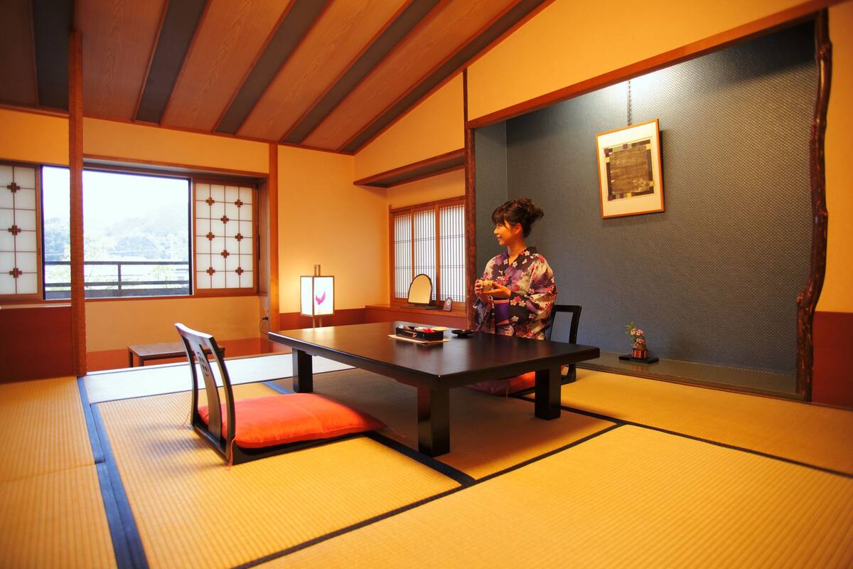A traditional Japanese room with tatami flooring, a low table, and sliding doors.