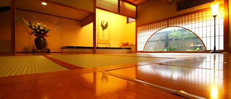 Una habitación tradicional japonesa con suelo de tatami, un celosía de papel y techo de madera.