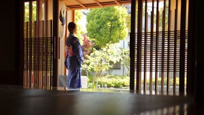 A traditional Japanese room with tatami flooring, sliding doors, and a view of a garden. - Onishiya Suishoen (Toyooka)