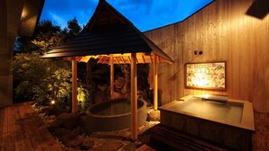 A wooden spa area with a hot tub and a wooden structure with a roof. - Onishiya Suishoen (Toyooka)