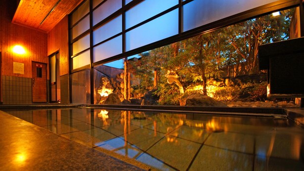 A modern building with large windows reflecting a landscaped garden. - Onishiya Suishoen (Toyooka)