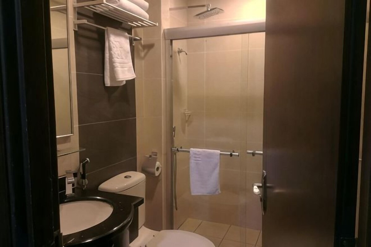 A bathroom with a sink, toilet, and a shower area.