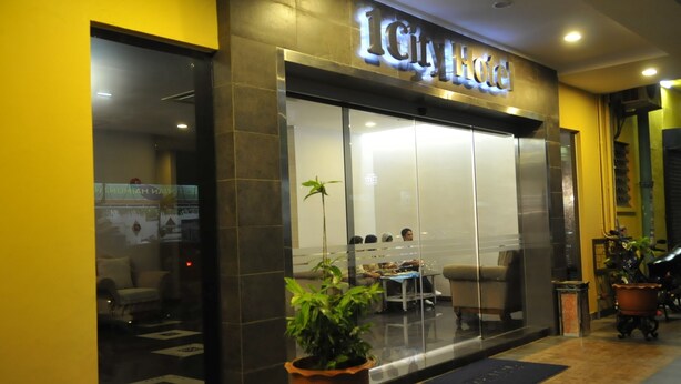 The exterior of the ICity Hotel with a modern design, large glass windows, and a visible seating area inside. - 1 City Hotel (Kota Kinabalu)