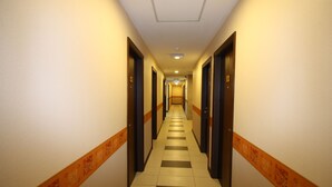 A hotel hallway with a checkered floor, doors on both sides, and a patterned carpet border. - 1 City Hotel (Kota Kinabalu)