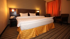 A hotel room with a large bed, two bedside tables, a desk, and a chair. - 1 City Hotel (Kota Kinabalu)
