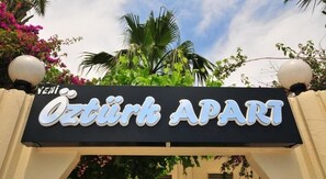 A sign for 'Öztürk APARI' with a clear view of the entrance and surrounding greenery.