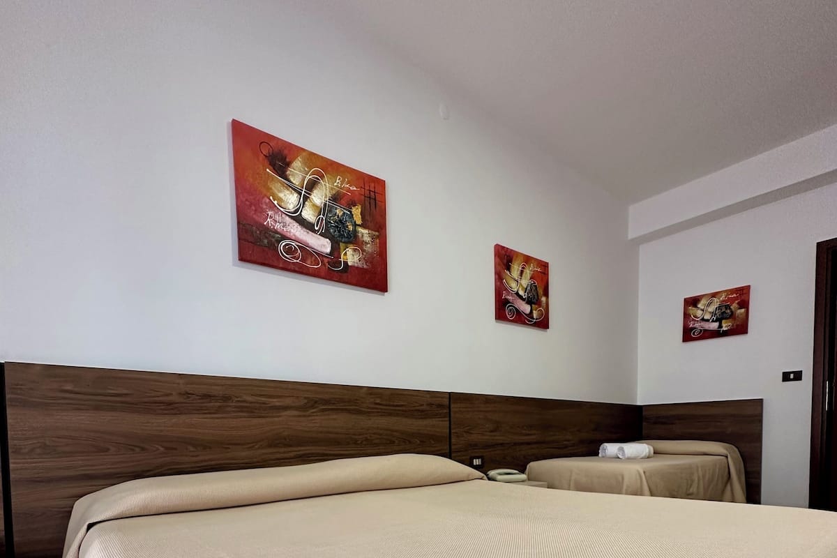 Camera Tripla con balcone vista piscina | Bureau, lits bébé (en supplément), draps fournis