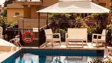 Outdoor pool, open 9:00 AM to 7:00 PM, pool umbrellas, pool loungers