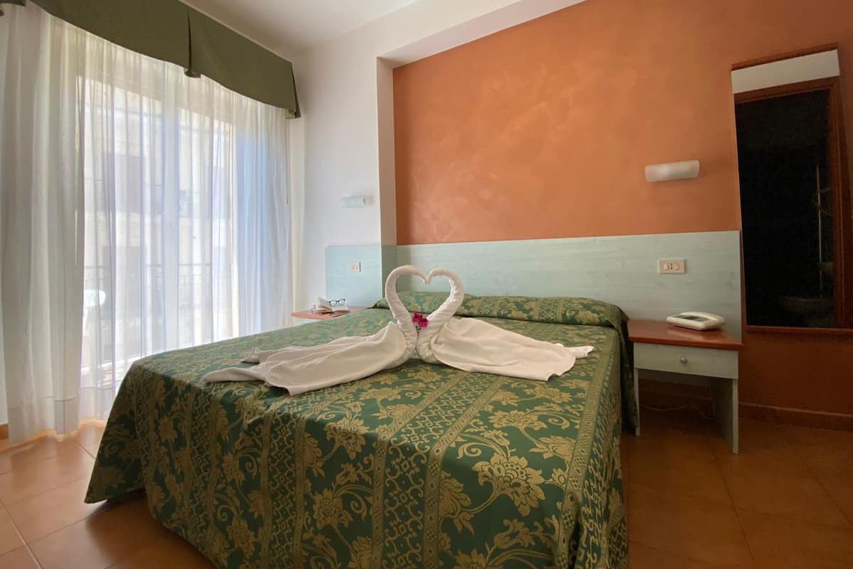 Habitación doble, balcón, vista parcial al mar | Escritorio, cunas y ropa de cama