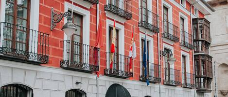 A red and white building with multiple balconies, a flag, and a sign that reads "Zenita".