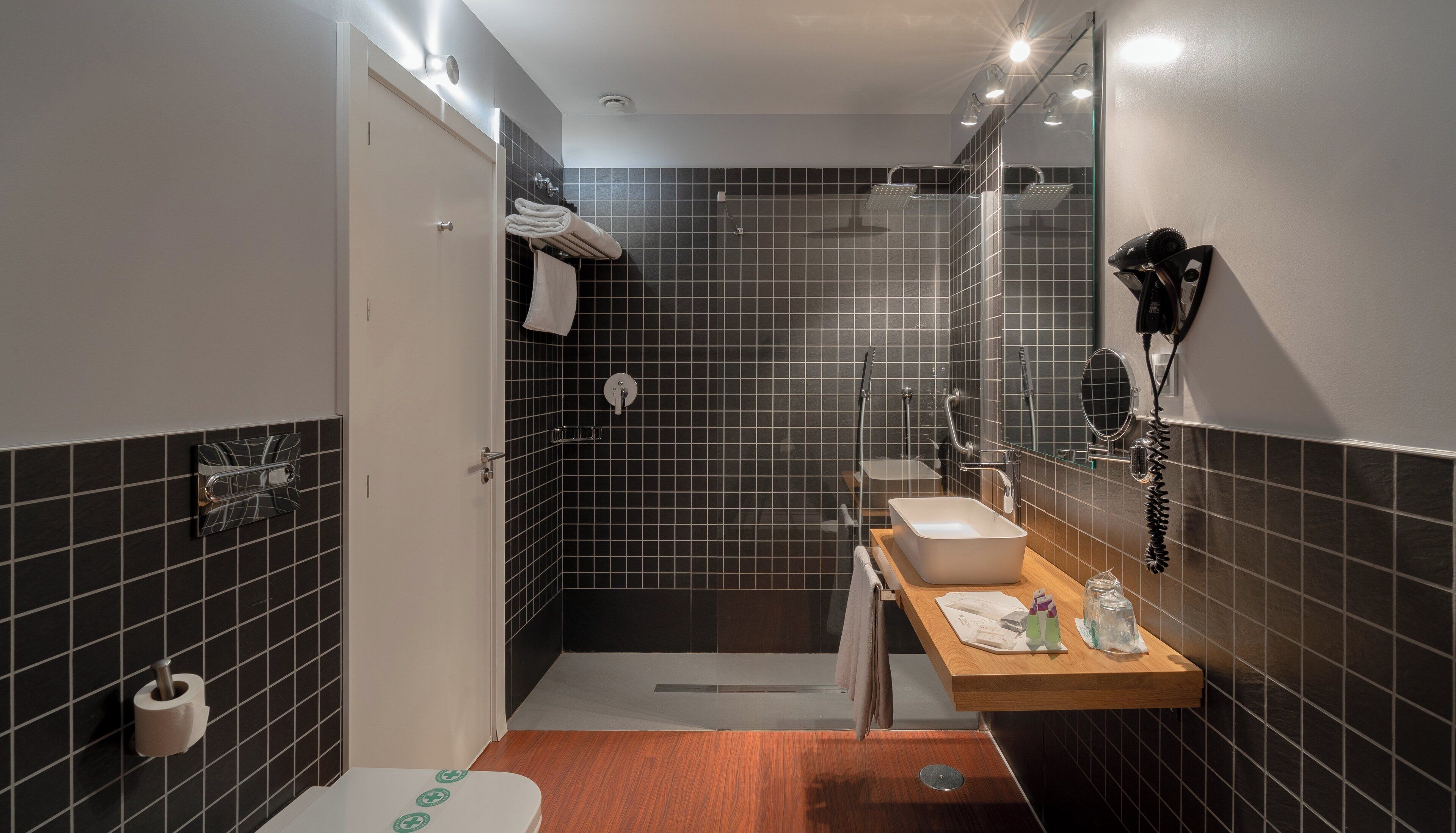 A modern bathroom with a shower, toilet, and sink.