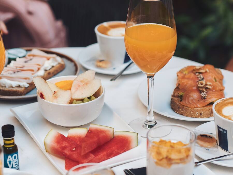A breakfast setting with various food items and drinks on a table.