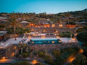 A resort with a pool, outdoor seating, and stone architecture. - Pantelleria Dream Resort (Pantelleria)