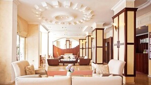 A spacious lobby with a modern ceiling design, a seating area with sofas and armchairs, and a reception desk. - Hotel Selen (Marmaris)