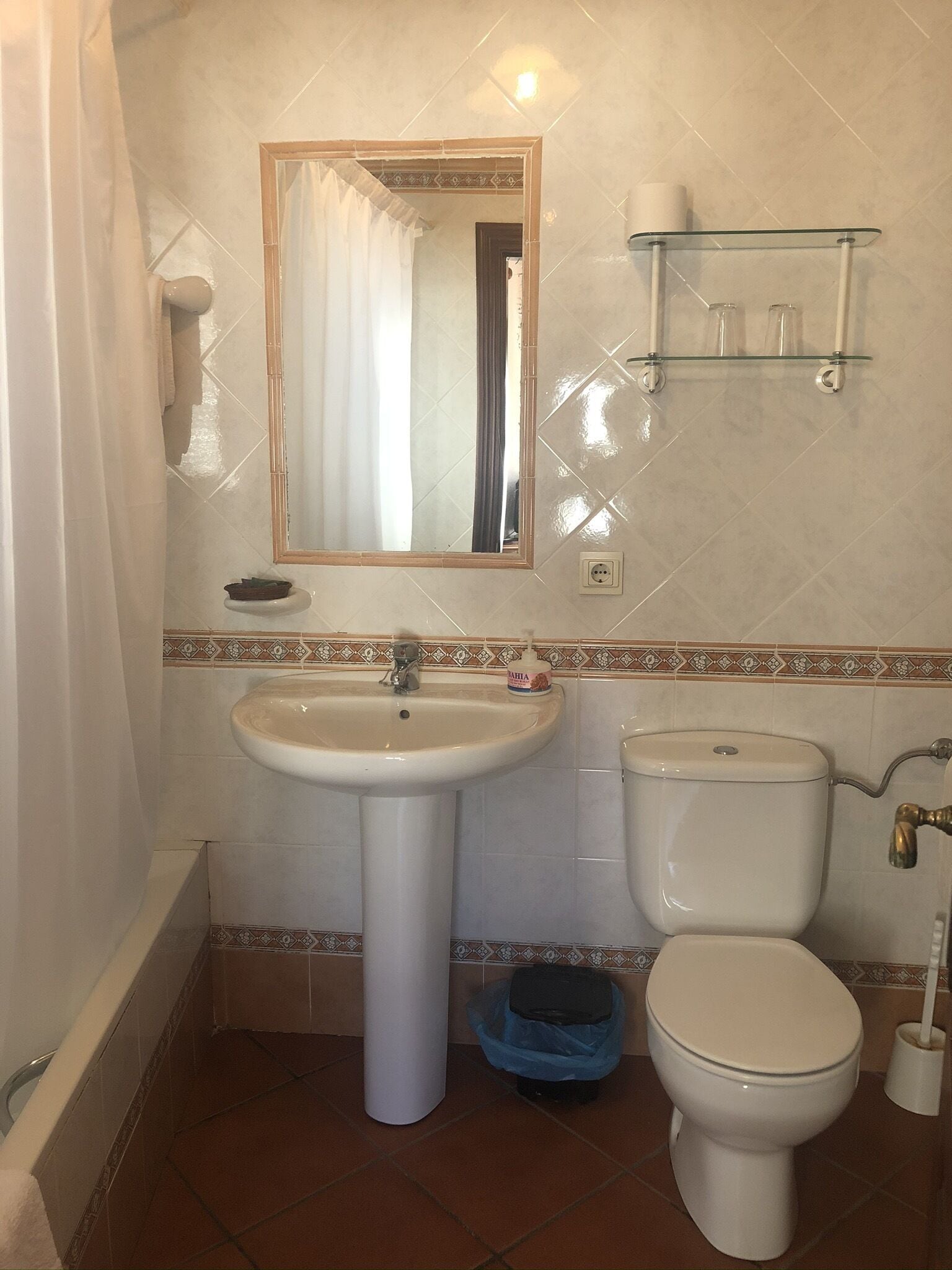 Un baño con lavamanos, inodoro y espejo.