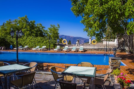 Una piscina al aire libre de temporada, sillones reclinables de piscina