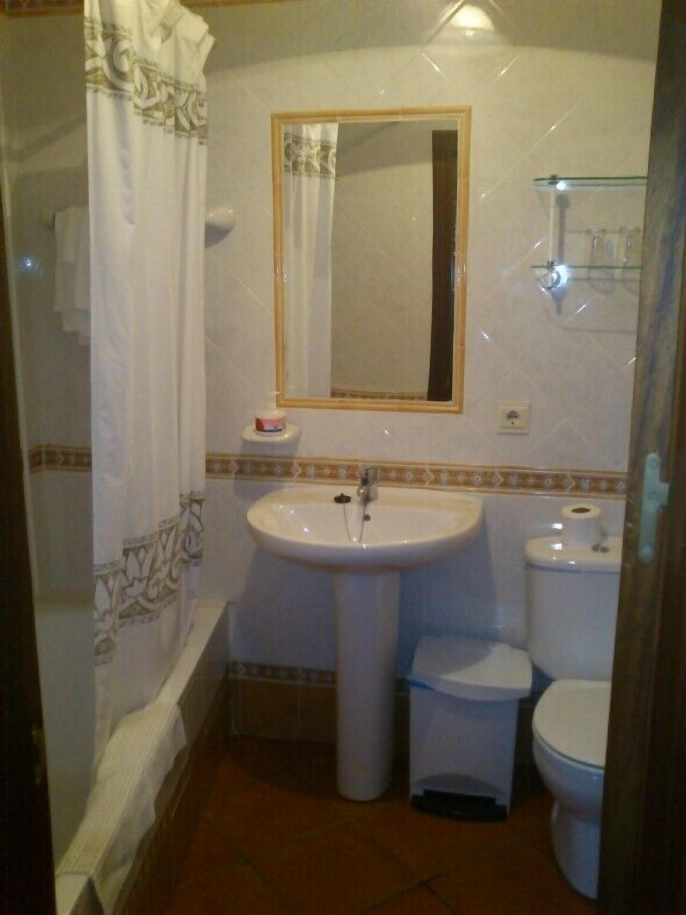 A small bathroom with a sink, toilet, and bathtub.