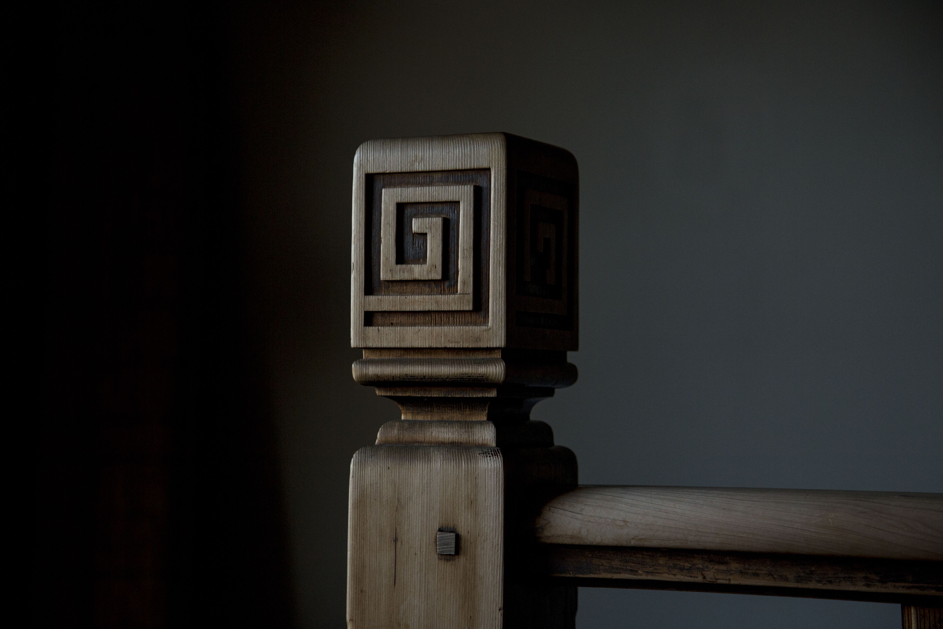 A wooden chair with a carved backrest and a visible screw.