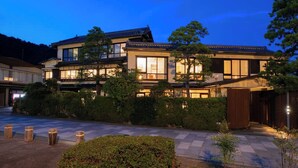 A traditional Japanese house with multiple levels, large windows, and a well-maintained garden. - Shinpuro (Miyazu)