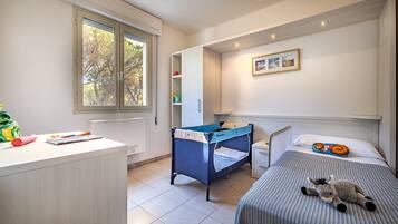Enjoy a peaceful retreat with a bed, desk, and window overlooking trees.