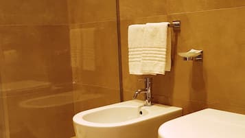 Un baño con dos lavamanos, un inodoro y una cabina de ducha de vidrio.