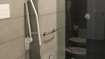 A modern bathroom with a toilet, bidet, and glass-enclosed shower.