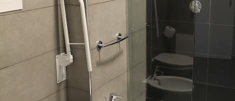 A modern bathroom with a toilet, bidet, and glass-enclosed shower.