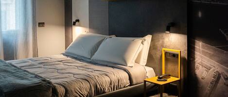A modern bedroom with a bed, bedside table, and a wall with text.