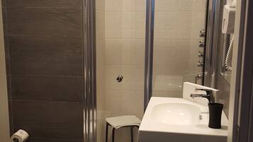 A modern bathroom with a shower, toilet, and sink.