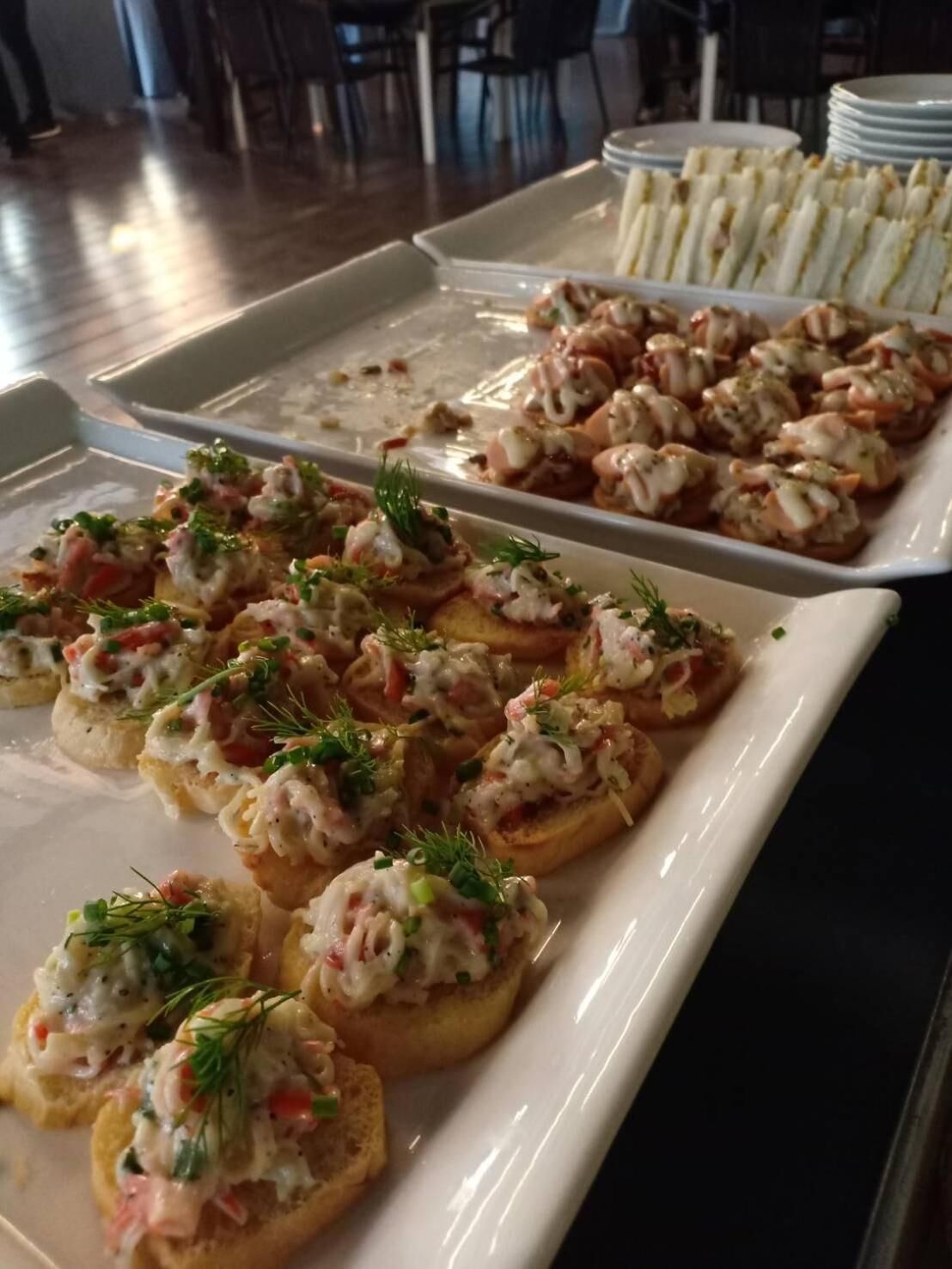 Un bufé con aperitivos de mariscos, incluyendo pan con camarones y otros platos.