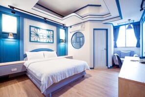 A modern bedroom with a large bed, a desk, and a chair. There is a window with curtains, a round mirror, and a decorative wall piece. - Tainan Inn (Tainan)