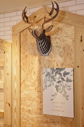 A wooden wall with a mounted antler and a framed botanical print. - Tainan Inn (Tainan)