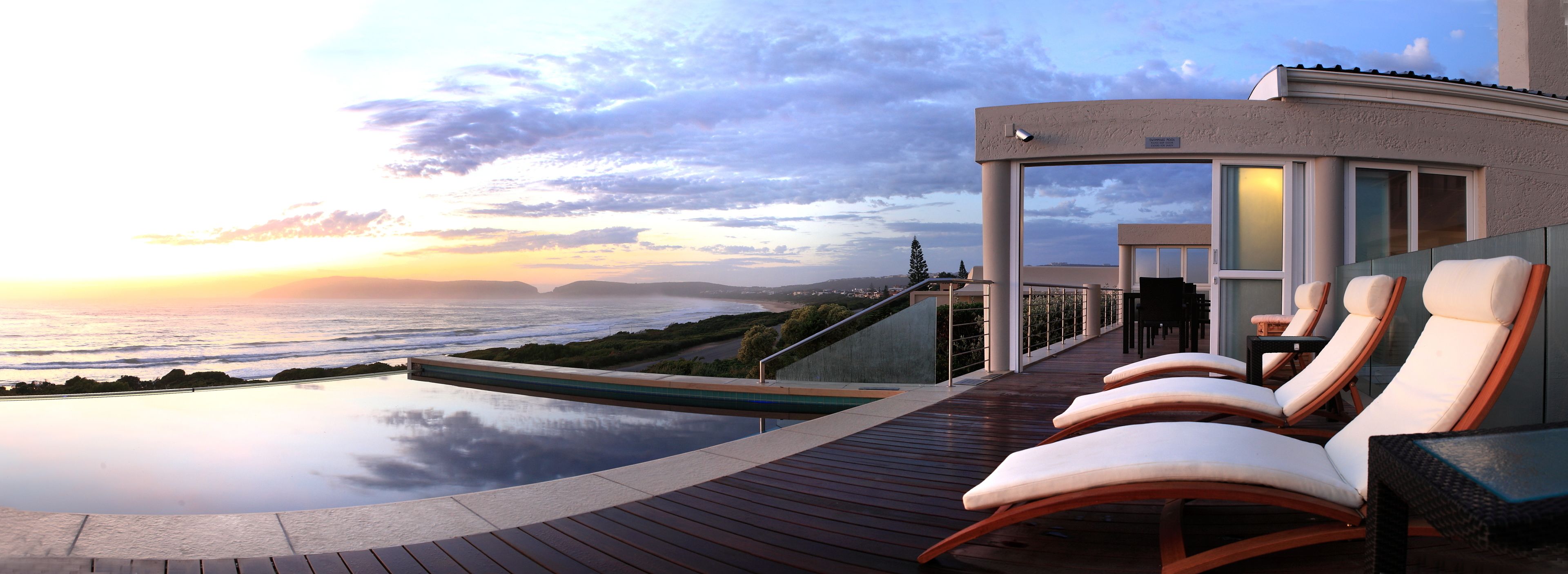 Una piscina al aire libre, sombrillas, tumbonas