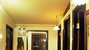 A narrow hallway with a bench, a sink, and a door leading to another room. - YHA Bangkok Airport - Hostel (Bang Phli)