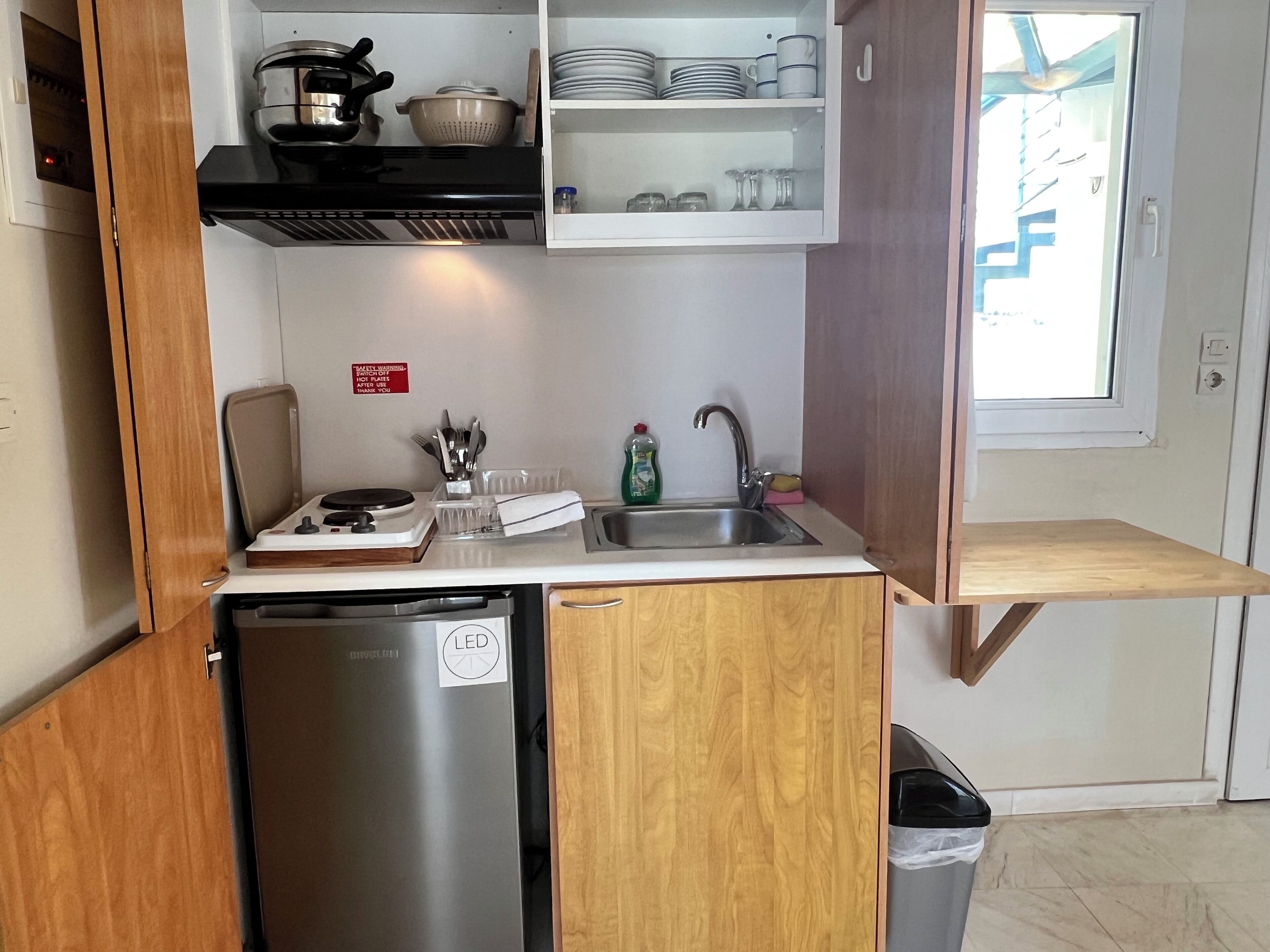 A compact kitchen with a built-in dishwasher, a sink, and a stove.