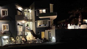 A multi-story hotel with balconies, outdoor seating, and a staircase. - Sea Breeze (Chania)