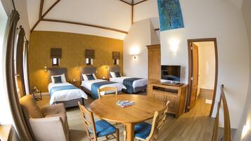 A hotel room with two beds, a wooden dining table, a TV, and a painting on the wall.