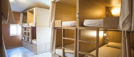 Una habitación con literas, un armario y una ventana.