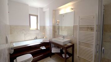 A modern bathroom with a bathtub, a sink, and a toilet.