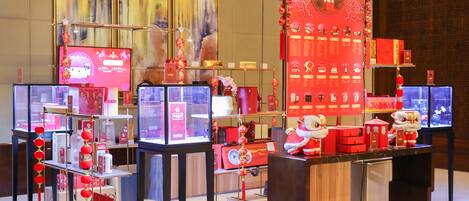 Une présentation de produits dans un magasin, comprenant divers articles, notamment des lanternes rouges et une figurine de danse du lion.