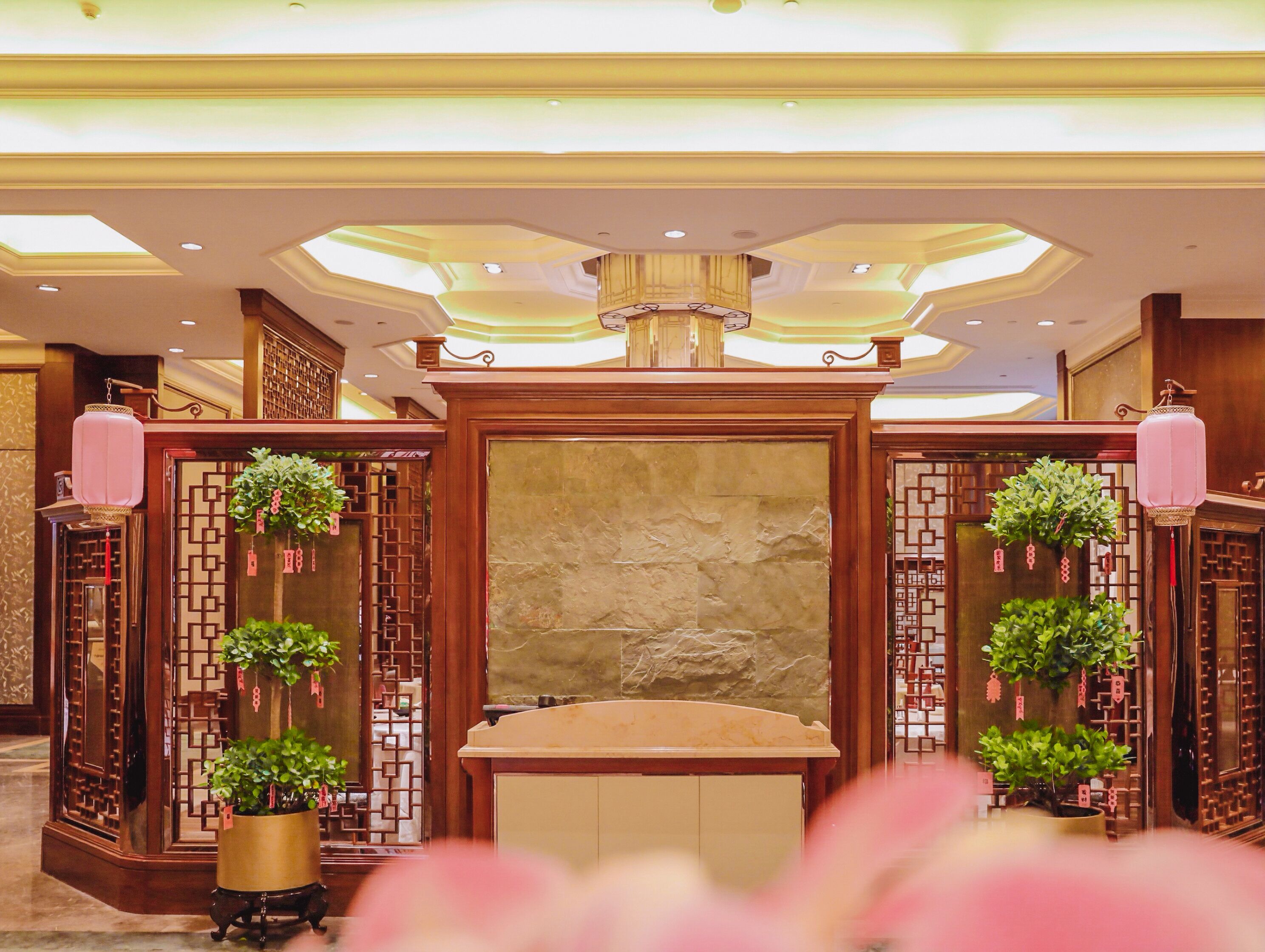 A reception area with a stone wall, wooden paneling, and potted plants.