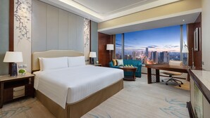 A hotel room with a large bed, a desk, a sofa, and a view of a cityscape. - Shangri-La Hefei (Hefei)