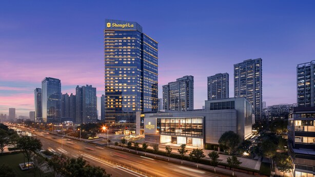A modern high-rise building with a prominent signage, surrounded by other high-rise buildings and a busy street with light trails indicating traffic. - Shangri-La Hefei (Hefei)