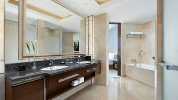 Un baño moderno con dos lavamanos, un espejo grande y una zona de ducha separada.
