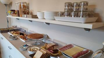 Disposição de buffet com diversos alimentos e utensílios.