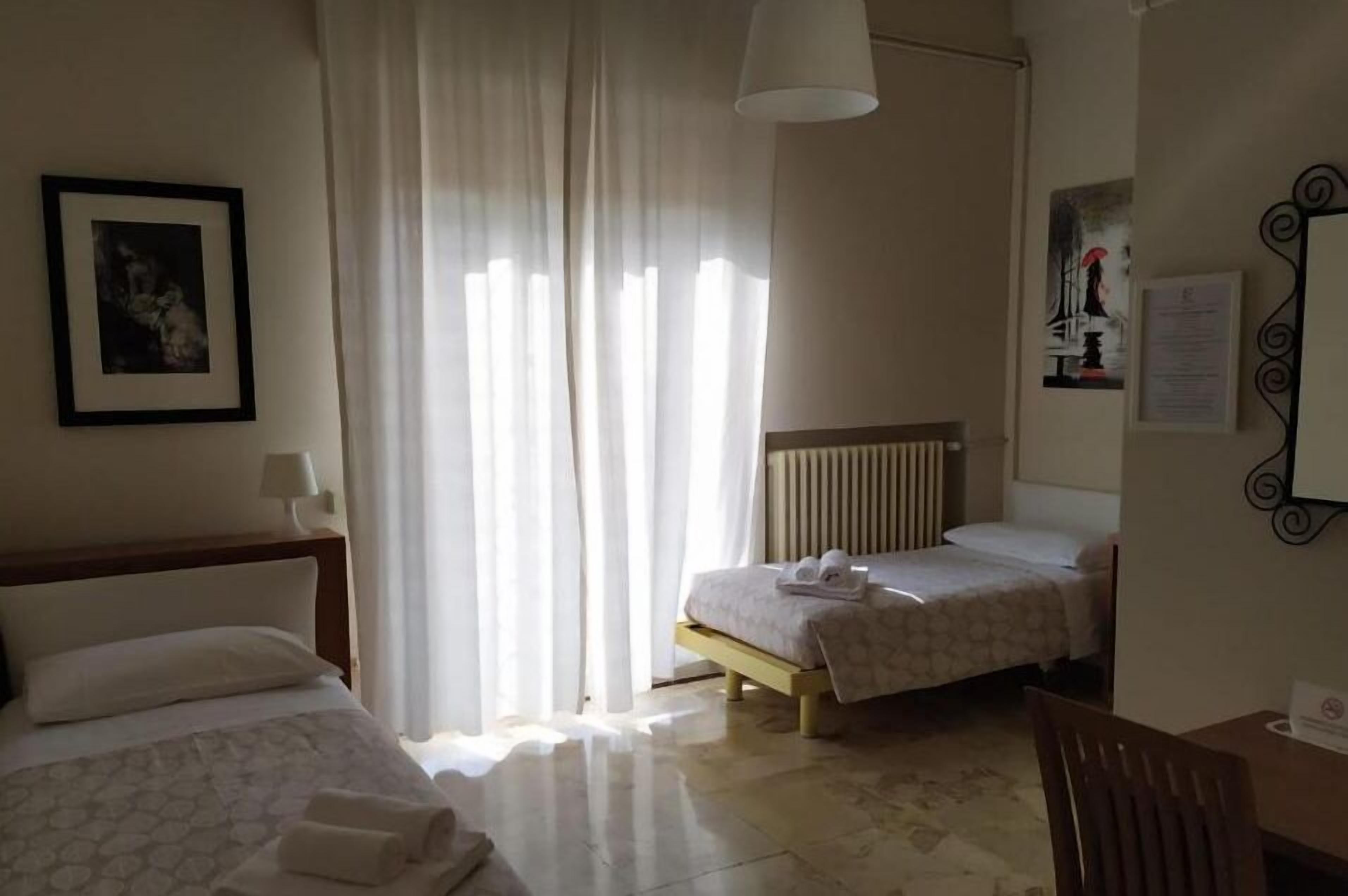 Una habitación de hotel con dos camas, un escritorio y una silla.