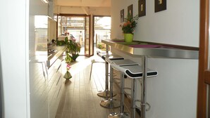 A kitchen with a bar area, stainless steel countertops, and a potted plant. - Cameracaffè sul Lago (Arezzo)