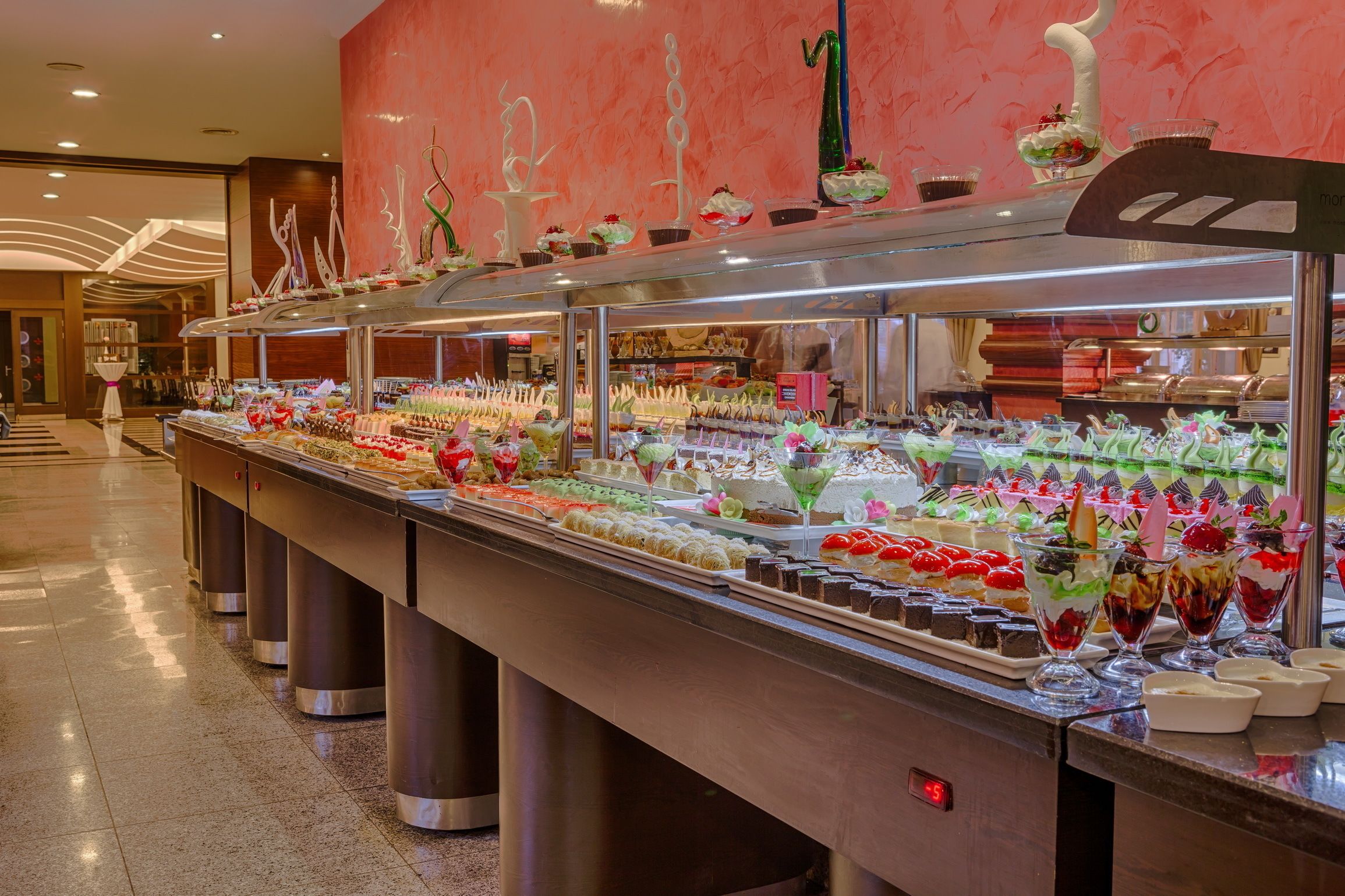 A buffet with a variety of desserts and beverages, including cakes, pastries, and fruit.