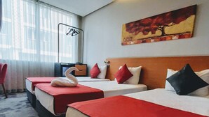 Une chambre d’hôtel avec deux lits, un bureau, une chaise et un tableau au mur.