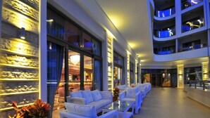 A modern hotel lobby with white wicker sofas, a glass coffee table, and a potted plant. - Golden Rock Beach Hotel - All Inclusive (Marmaris)
